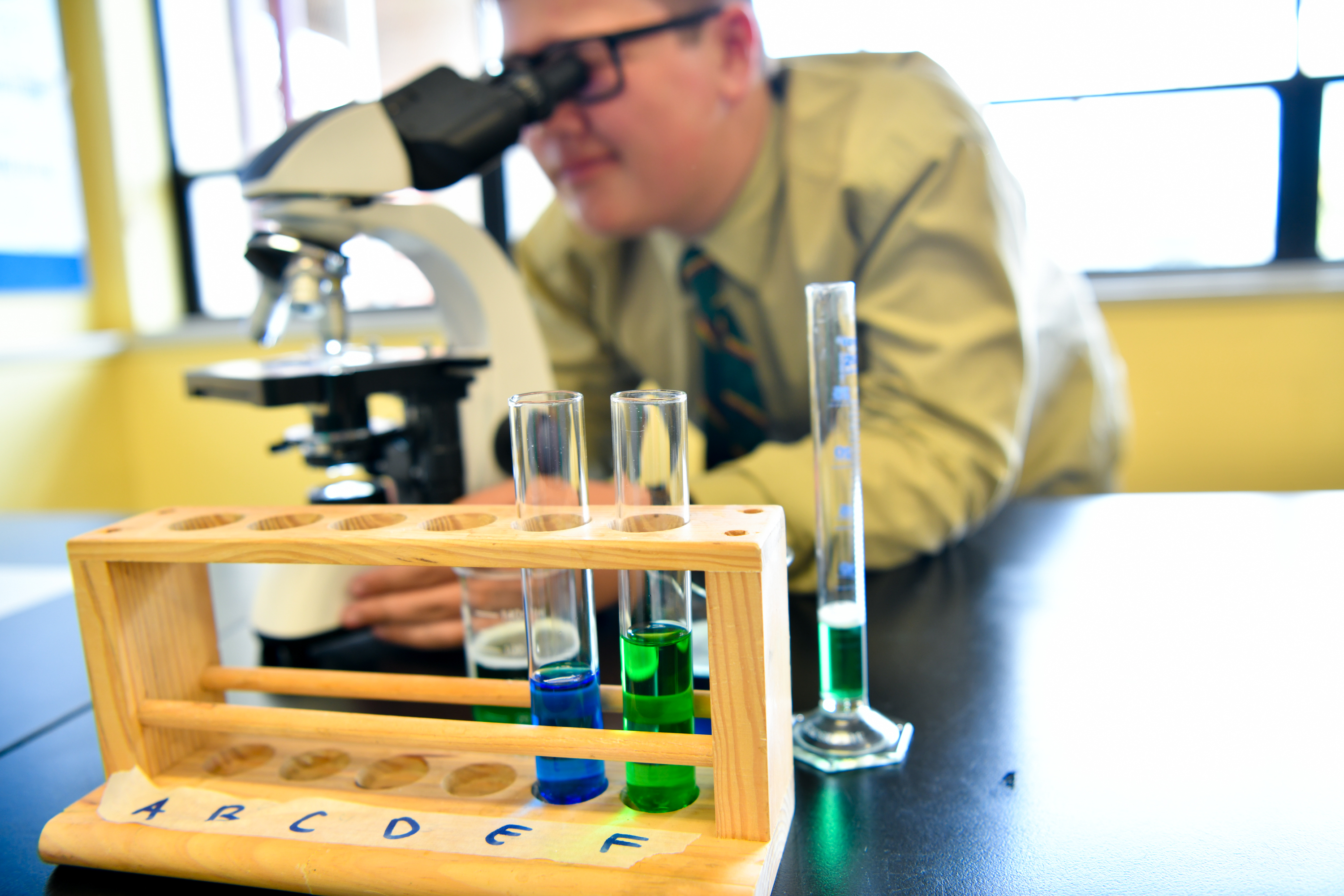 Student and Staff looking down microscope